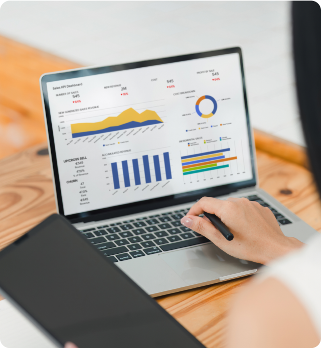 Image of a person/teammate working on their laptop, with charts & graphs outlining the potential dashboard of data.