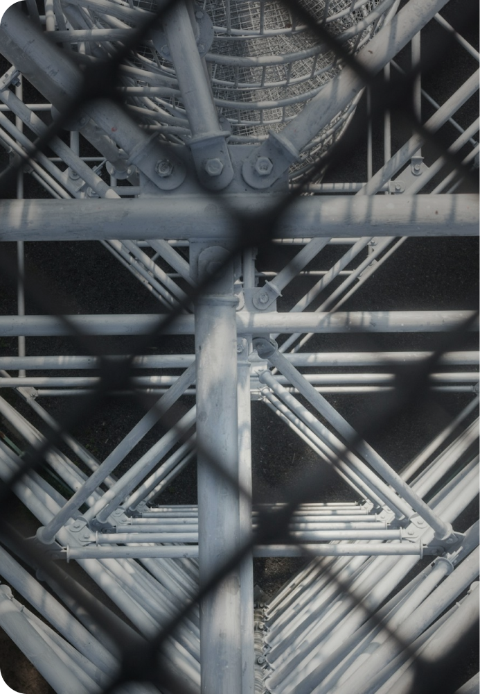 A photograph of a modern building with the photographr shooting up, showing the sheer height and steel beams.