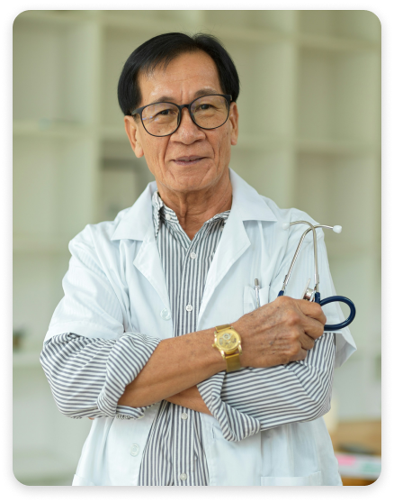 An older, asian doctor looking at the camera and smiling.